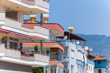 City view on a sunny day. Modern building and houses against the blue sky.