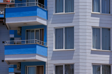 City view on a sunny day. Modern building and houses against the blue sky.