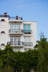 City view on a sunny day. Modern building and houses against the blue sky.