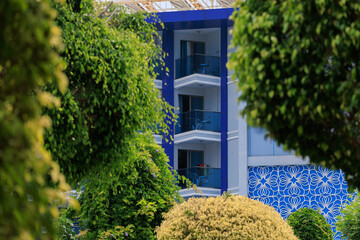 City view on a sunny day. Modern building and houses against the blue sky.