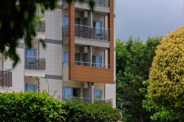 City view on a sunny day. Modern building and houses against the blue sky.