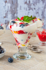 Vanilla ice cream dessert with fresh fruit and raspberry coulis