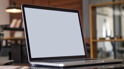 Fototapeta premium A laptop on a desk set in a modern office.