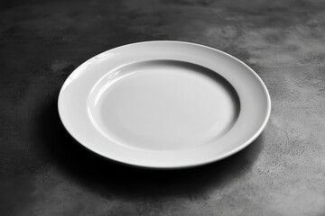 A stark, minimalist image featuring an empty white plate on a textured, dark-gray table, evoking feelings of emptiness and contemplation.