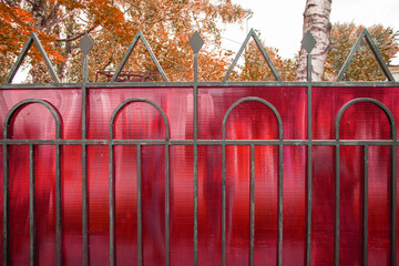 A fragment of a fence made of steel pipes and polycarbonate to protect private property, a summer...