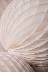 A close-up shot of a white, honeycomb paper decoration, showcasing intricate textures and soft lighting.