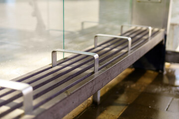 bus stop bench reinforced with metal railings serves as a stark reminder of societal boundaries, discouraging loitering and aiming to maintain public order