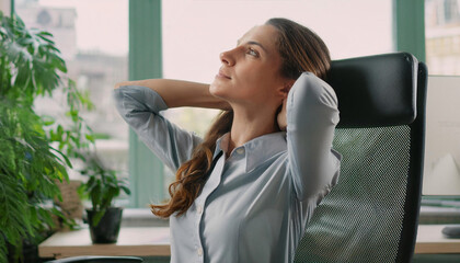 Obraz premium Close-up of a young businesswoman in the office doing stretching exercises. 