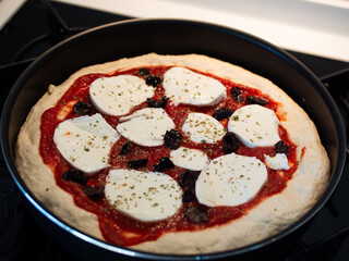 Italian Neapolitan pizza with mozzarella cheese ready to go in the oven