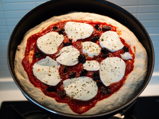 Italian Neapolitan pizza with mozzarella cheese ready to go in the oven