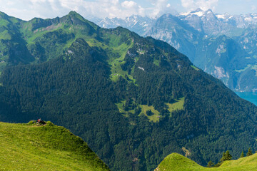 Obraz premium The Stoos hike in summer offers breathtaking views of the Swiss Alps, lush green meadows, and serene lakes. The trail is accessible yet challenging, with panoramic vistas that make every step rewardin