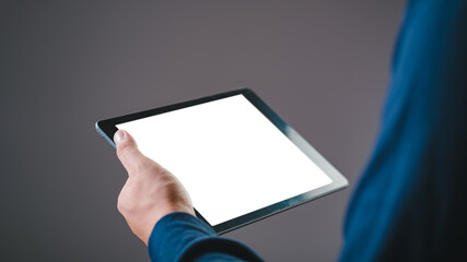Person holding a digital tablet with a blank white screen, suitable for mockups, presentations, and digital content demonstrations.