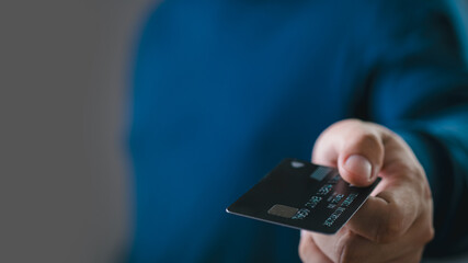 Close-up of a hand holding a credit card. Concept of online shopping, electronic payment, and financial transactions.