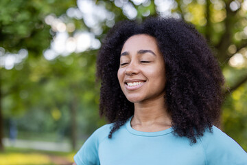 Smiling African American female athlete partakes in an outdoor fitness class, standing among...