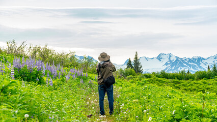 Fototapeta premium Photographer in the Alaska wilderness photographs mountains