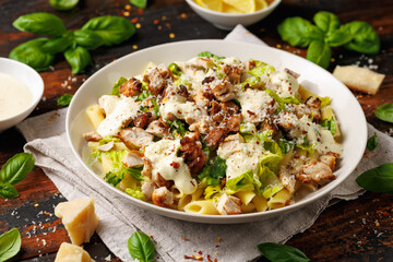 Chicken Caesar Pasta Salad with sauce in white plate. Healthy food.