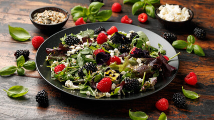 Summer berries salad with edible flowers, feta cheese and seeds