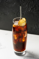Soft drink cola with pickles and ice in a glass.