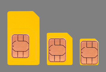 yellow mini, micro and nano SIM cards isolated on a gray background top view