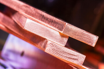 Copper flat bars, clean and polished on blurred colorful background, close-up view