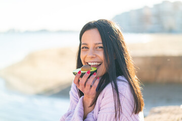 Young woman at outdoors holding an avocado at outdoors