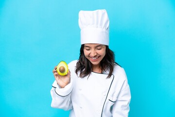 Young hispanic chef woman holding avocado isolated on blue background smiling a lot