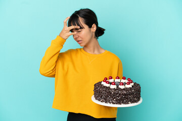 Young mixed race woman holding birthday cake with headache