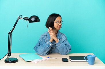 Young student mixed race woman studying on a table scheming something