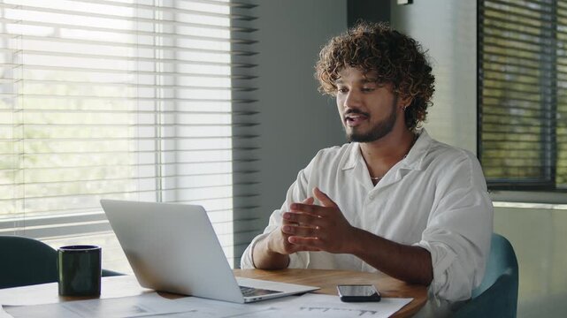 Indian business man having virtual meeting working on laptop computer giving online training, remote class on video conference call.