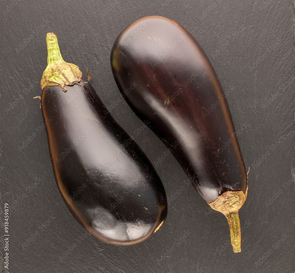 Wall mural two ripe eggplants on slate stone, macro, top view.