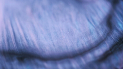 Glitter wave. Paint water flow. Defocused purple blue color shimmering shiny texture fluid blend...