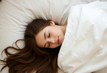 Obraz premium A young Caucasian woman with long brown hair sleeping peacefully on a white pillow