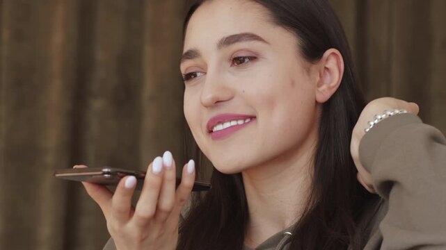 Audio message communication. Young girl recording answer using voice assistant on cellphone at home