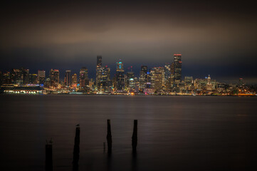Seattle sunrise looking across Elliott Bay from West Seattle. Old pilings frame the modern skyscrapers during the blue hour of this magnificent cityscape located in the Pacific Northwest.