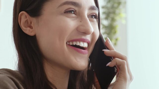 Love on distance. Playful girl talking on cellphone, flirting with boyfriend at home