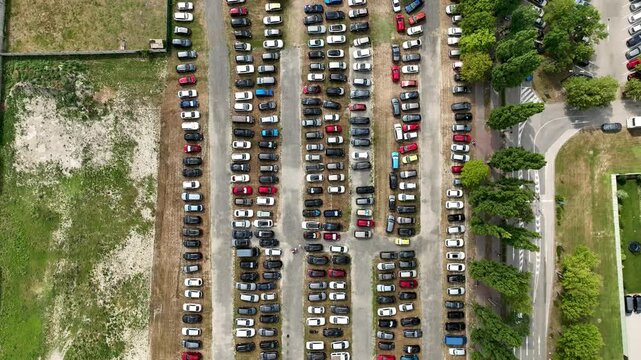 Aerial view of a busy car parking area with parallel parked vehicles