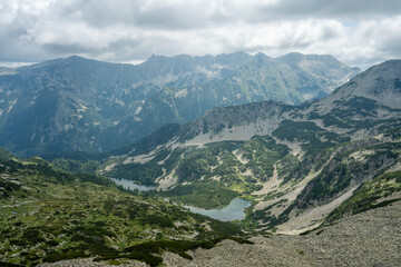 Naklejka premium Upper and lower Vasilashki lakes under overcast sky captured from a ridge next to Todorka in June