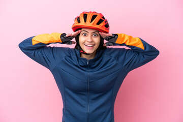 Teenager cyclist girl isolated on pink background with surprise expression