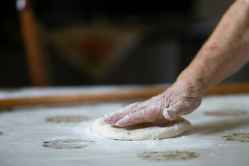 Old woman hand kneading dough