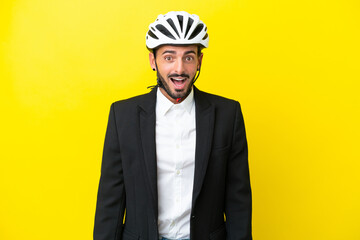 Business caucasian man with a bike helmet isolated on yellow background with surprise facial expression