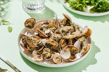 Vongole with basil and onion on a white plate