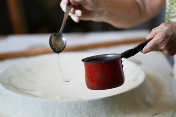 Rolled out dough and rolling pin on a table. Pouring flour on the dough