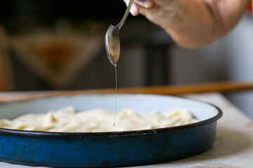 Rolled out dough and rolling pin on a table. Pouring flour on the dough