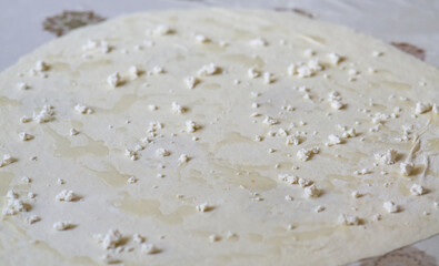 Rolled dough with crumbled cheese and oil