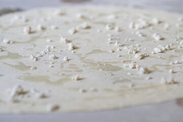 Rolled dough with crumbled cheese and oil