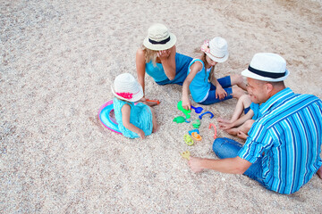 A Happy family playing by the sea shore on the sand background