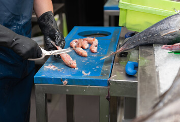 fishmonger cleaning red mullet for sale