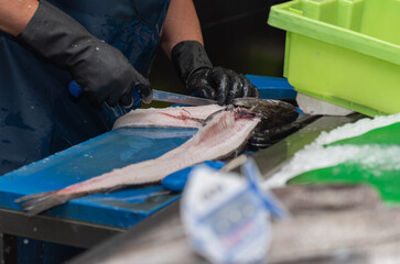 fishmonger cleaning fish for sale