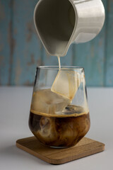 milk being poured into coffee