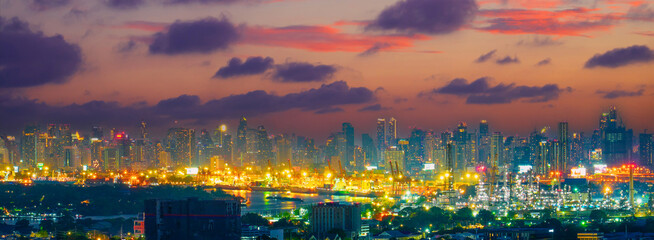 Night view of city silhouettes of buildings and skyscrapers, the dying sky after sunset and clouds